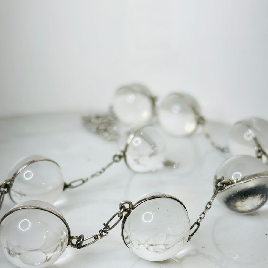 Necklace with 9 rock crystal orbs, called Pools of Light, and sterling silver chain.